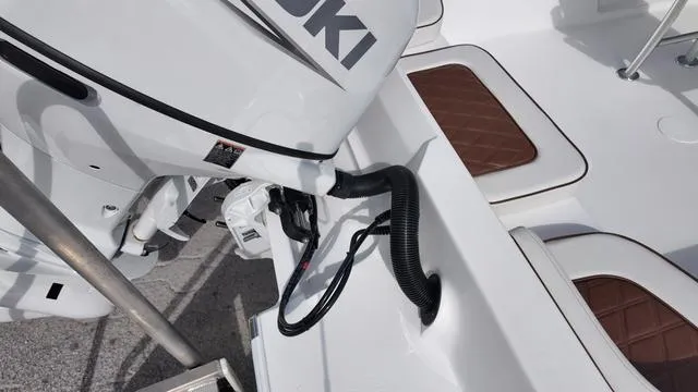 Slide: The Image of Outboard motor on ALK2 22CRX boat, 2025 model, with brown cushioned seats. - 22