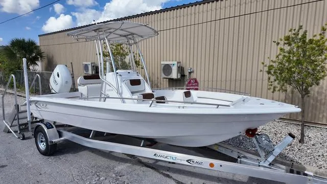 Slide: The Image of White ALK2 22CRX 2025 boat on trailer, parked outdoors near a beige building. - 25
