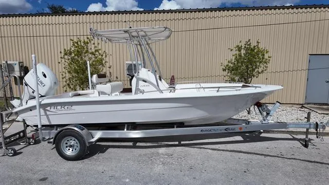 Slide: The Image of 2025 ALK2 22CRX boat on trailer, parked outdoors near a beige building. - 6