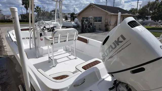 Slide: The Image of White ALK2 22CRX 2025 boat with Suzuki outboard motor, docked near a building. - 9