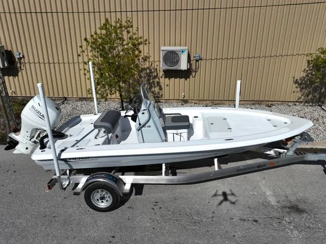 Slide: The Image of 2025 ALK2 17HS boat on trailer, parked outdoors near a beige building. - 25