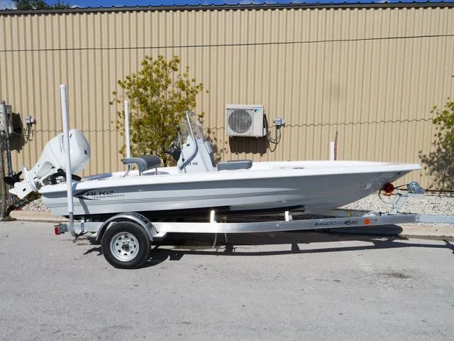 Slide: The Image of 2025 ALK2 17HS boat on trailer, parked outdoors near a beige building. - 6