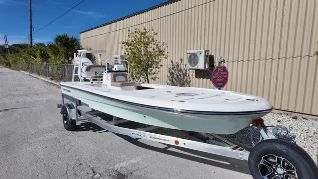 Slide: The Image of 2025 Spyder Boats FX19 Vapor on trailer, parked outdoors near a building. - 19
