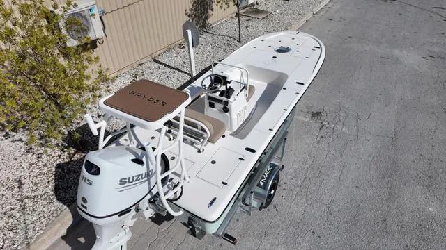 Slide: The Image of 2025 Spyder Boats FX19 Vapor on trailer, featuring Suzuki outboard motor, parked on concrete. - 20