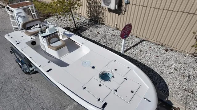 Slide: The Image of 2025 Spyder Boats FX19 Vapor, sleek design, white deck, parked outdoors. - 3