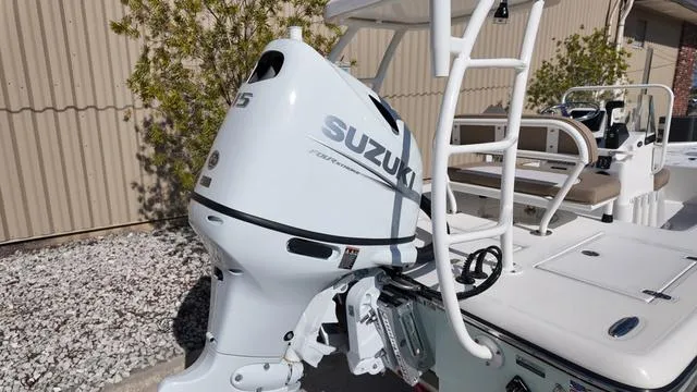 Slide: The Image of 2025 Spyder Boats FX19 Vapor with Suzuki outboard motor, docked outdoors. - 9