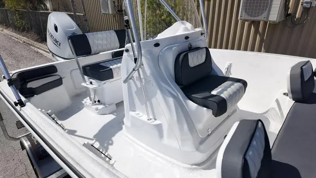 Slide: The Image of 2025 ALK2 18CRS boat interior with cushioned seating and steering console. - 10
