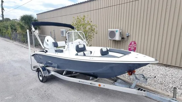 Slide: The Image of 2025 ALK2 18CRS boat on trailer, parked outdoors near a building. - 19