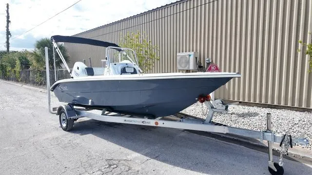 Slide: The Image of 2025 ALK2 18CRS boat on trailer, parked beside a corrugated metal building. - 20