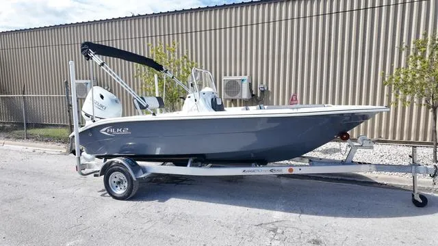 Slide: The Image of 2025 ALK2 18CRS boat on trailer, parked outdoors near industrial building. - 21