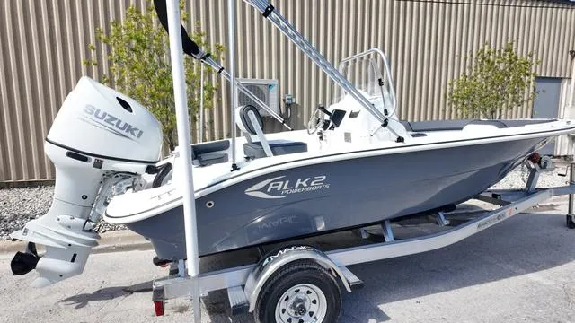 Slide: The Image of 2025 ALK2 18CRS boat with Suzuki outboard motor on a trailer, parked outdoors. - 25