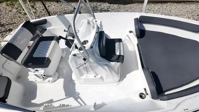 Slide: The Image of 2025 ALK2 18CRS boat interior with cushioned seating and steering console. - 32