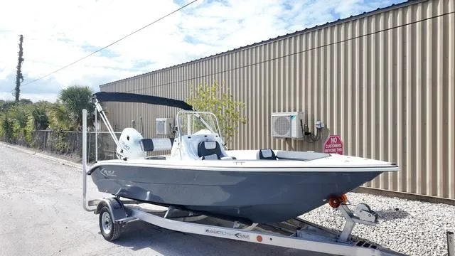 Slide: The Image of 2025 ALK2 18CRS boat on trailer, parked outdoors near a corrugated metal building. - 33