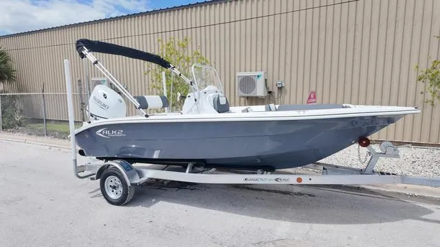 Slide: The Image of 2025 ALK2 18CRS boat on trailer, parked outdoors near a beige building. - 36