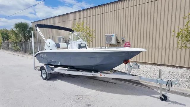 Slide: The Image of 2025 ALK2 18CRS boat on trailer, parked outdoors near a beige building. - 38