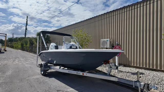Slide: The Image of 2025 ALK2 18CRS boat on trailer, parked outdoors near a metal building. - 45