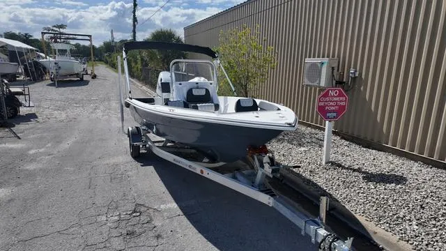 Slide: The Image of 2025 ALK2 18CRS boat on trailer, parked outdoors near a metal building. - 47