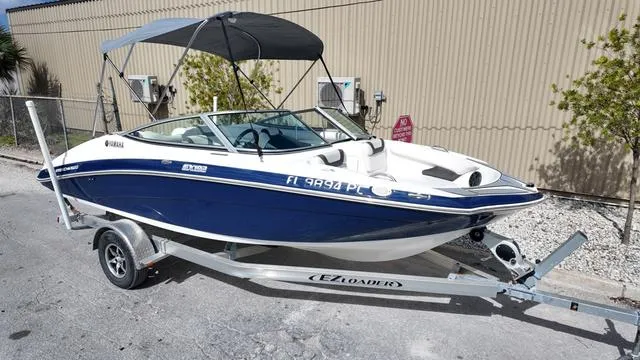 Slide: The Image of 2013 Yamaha Boats SX192 on trailer with canopy, parked outdoors. - 12