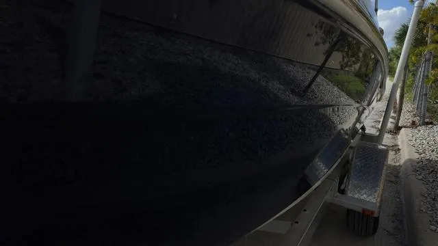 Slide: The Image of 2013 Yamaha Boats SX192 on trailer, side view with dark hull and reflective surface. - 15