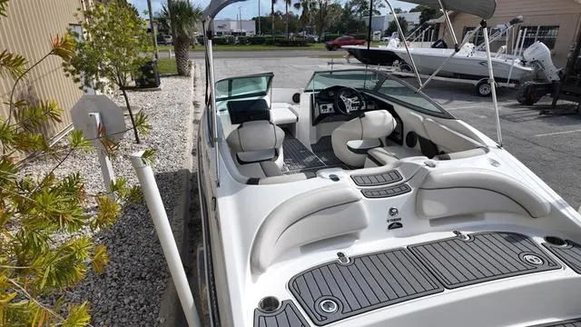 Slide: The Image of 2013 Yamaha Boats SX192, sleek white interior, docked outdoors, showcasing seating and dashboard. - 6