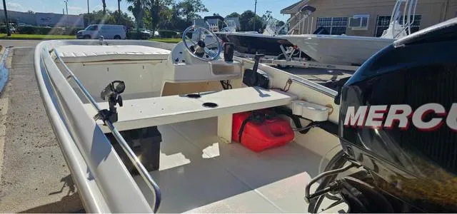 Slide: The Image of 2012 Boston Whaler SPORT 130 boat interior with steering wheel and Mercury engine. - 3