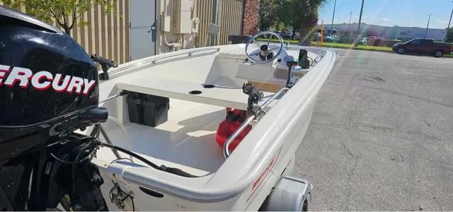 Slide: The Image of 2012 Boston Whaler SPORT 130 boat with Mercury engine, parked outdoors. - 4