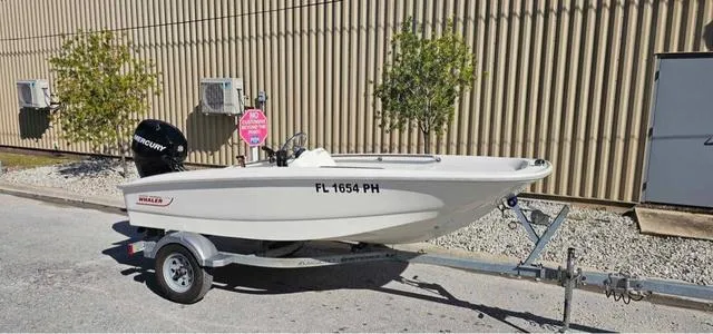 Slide: The Image of 2012 Boston Whaler SPORT 130 boat on trailer, parked outdoors. - 5