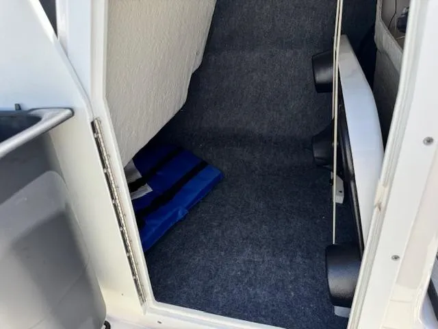 Slide: The Image of Interior storage compartment of a 2021 Yamaha Boats 195S, featuring carpeted flooring. - 11