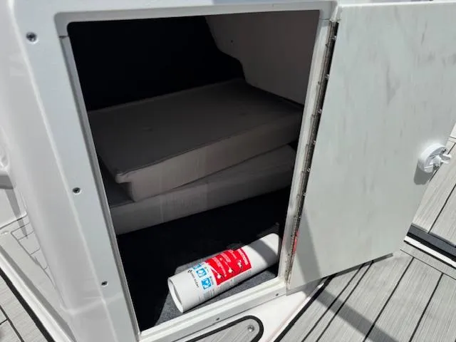 Slide: The Image of Open storage compartment on 2021 Yamaha Boats 195S, showing interior space and a fire extinguisher. - 13