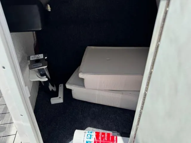 Slide: The Image of Storage compartment of a 2021 Yamaha Boats 195S, featuring cushions and equipment. - 14