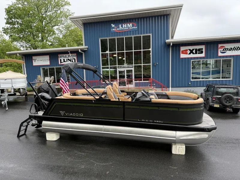 The Image of 2025 Viaggio X20U Tri-Toon boat with 25" tubes displayed outside dealership. - 1