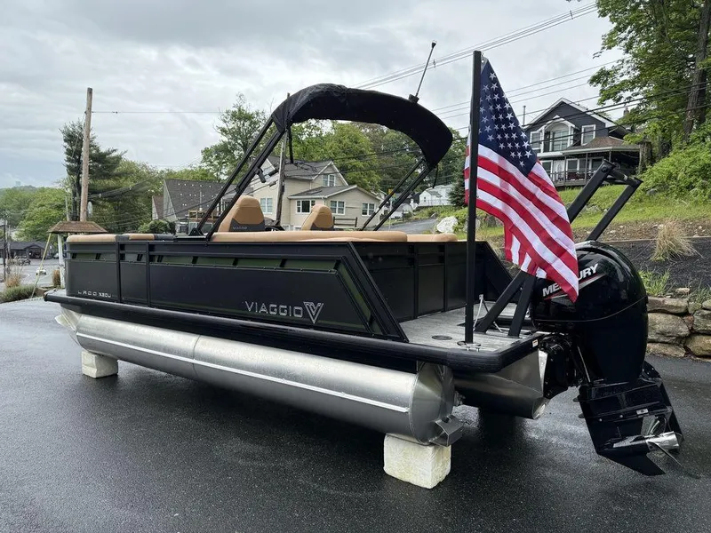 Slide: The Image of 2025 Viaggio X20U Tri-Toon boat with American flag and Mercury engine on display. - 4