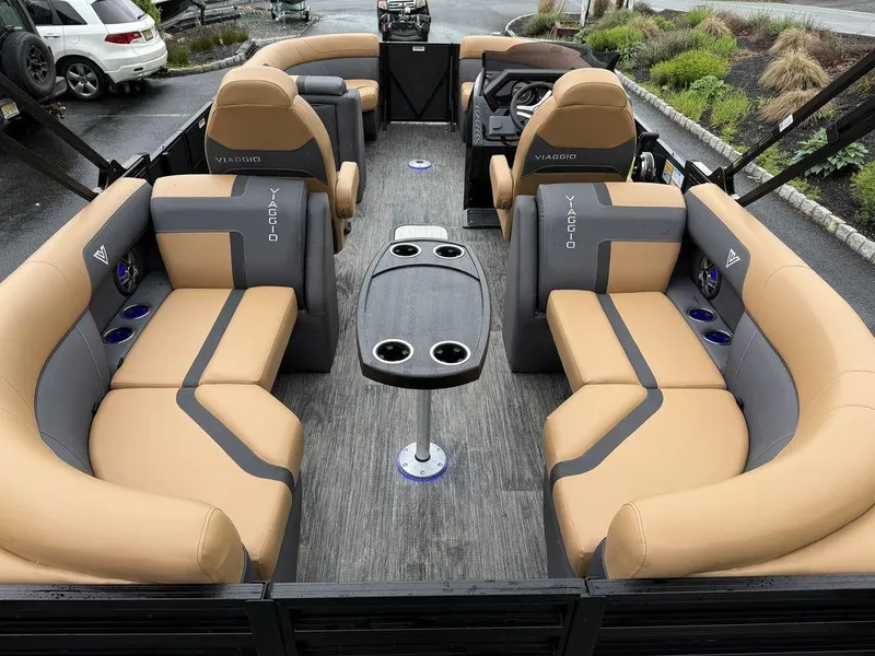 Slide: The Image of 2025 Viaggio X20U Tri-Toon boat interior with tan seating and central table. - 9
