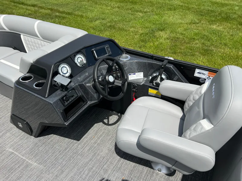 Slide: The Image of 2025 Crest Classic 220 SLRC boat interior with steering wheel and comfortable seating. - 12