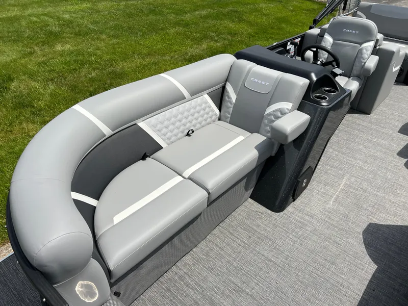 Slide: The Image of 2025 Crest Classic 220 SLRC pontoon boat docked by a scenic lake. - 3