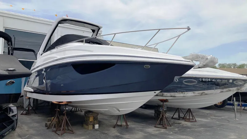 The Image of 2025 Regal 28 Express boat on stands, sleek design under blue sky. - 0