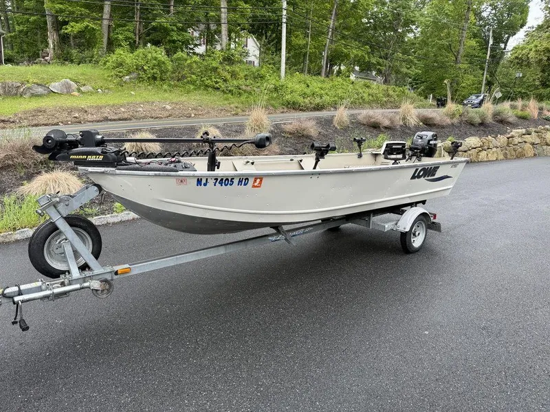 Slide: The Image of 2011 Lowe ANGLER A1667 boat on trailer, parked on a paved road. - 6