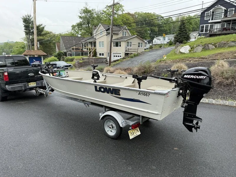 Slide: The Image of 2011 Lowe ANGLER A1667 boat on trailer, attached to a truck, with Mercury outboard motor. - 7