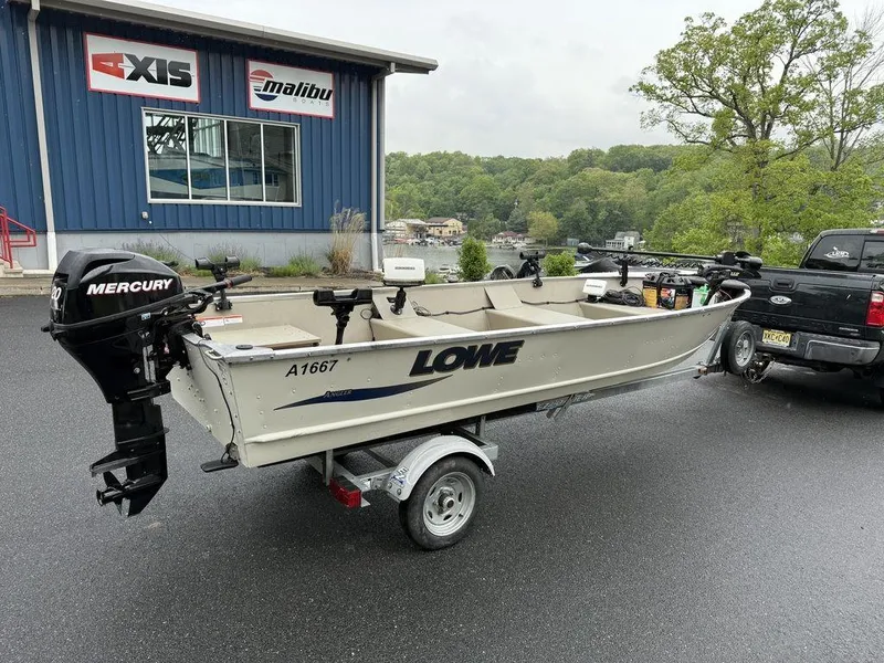 Slide: The Image of 2011 Lowe ANGLER A1667 boat on trailer with Mercury motor, parked outside dealership. - 9