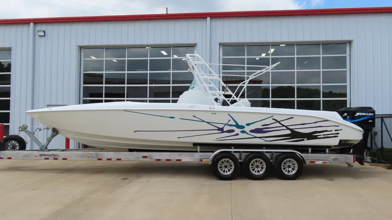 The Image of 2002 Baja 340 Sportfish boat on trailer, parked outside a garage. - 1