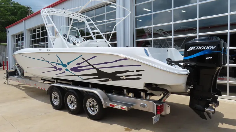 Slide: The Image of 2002 Baja 340 Sportfish boat on trailer with Mercury outboard engine, parked outside a garage. - 3