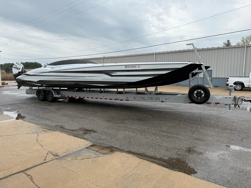 Slide: The Image of 2021 MTI 390X powerboat on trailer, parked outdoors near industrial building. - 2