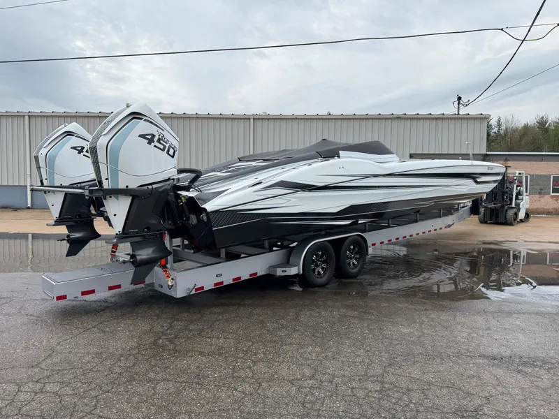 Slide: The Image of 2021 MTI 390X powerboat on trailer with dual 450 engines, parked outside a warehouse. - 3