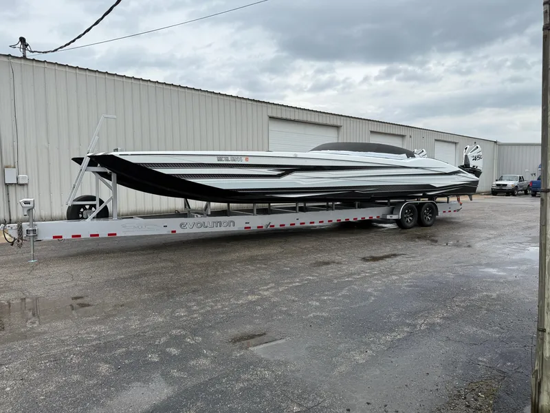 Slide: The Image of 2021 MTI 390X boat on trailer outside industrial building under cloudy sky. - 6