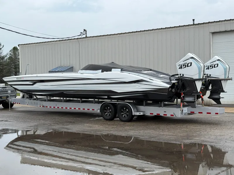 Slide: The Image of 2021 MTI 390X powerboat on trailer with twin 450 engines, parked outside a warehouse. - 8