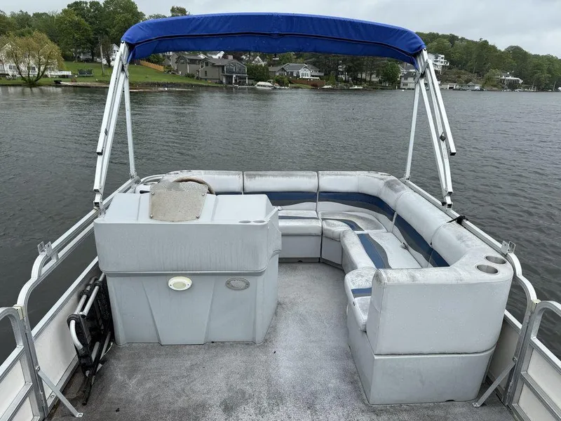 Slide: The Image of 2005 Smoker Craft INFINITY pontoon boat with blue canopy on a serene lake. - 4