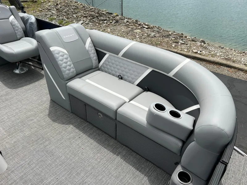Slide: The Image of 2025 Crest Classic 220 SLRC pontoon boat with luxurious gray seating and cup holders by the water. - 10