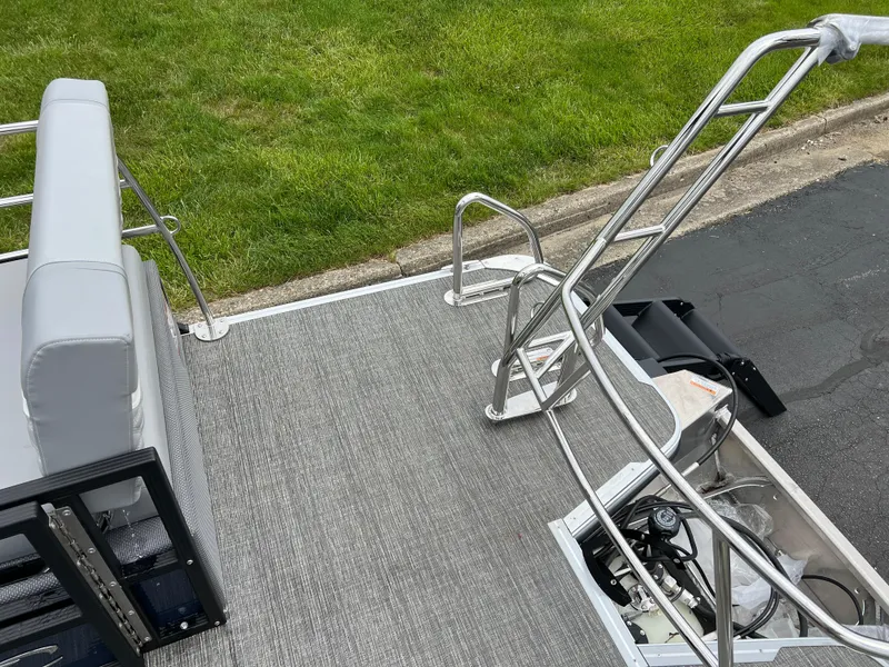 Slide: The Image of 2025 Crest Classic 220 SLRC pontoon boat with gray seating and stainless steel railings. - 14