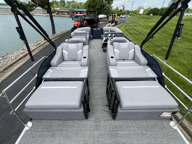 Slide: The Image of 2025 Crest Classic 220 SLRC pontoon boat with luxurious seating and scenic lakeside view. - 16