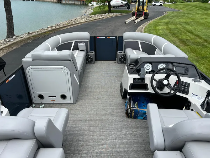 Slide: The Image of 2025 Crest Classic 220 SLRC pontoon boat interior with gray seating and steering console. - 18